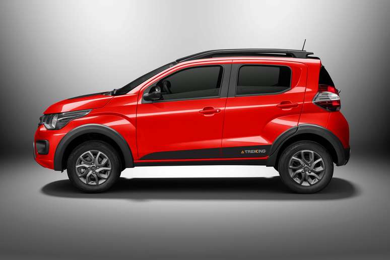 Side view of a bright red compact SUV with a sleek design, featuring black trim and sporty wheels against a gradient gray background.
