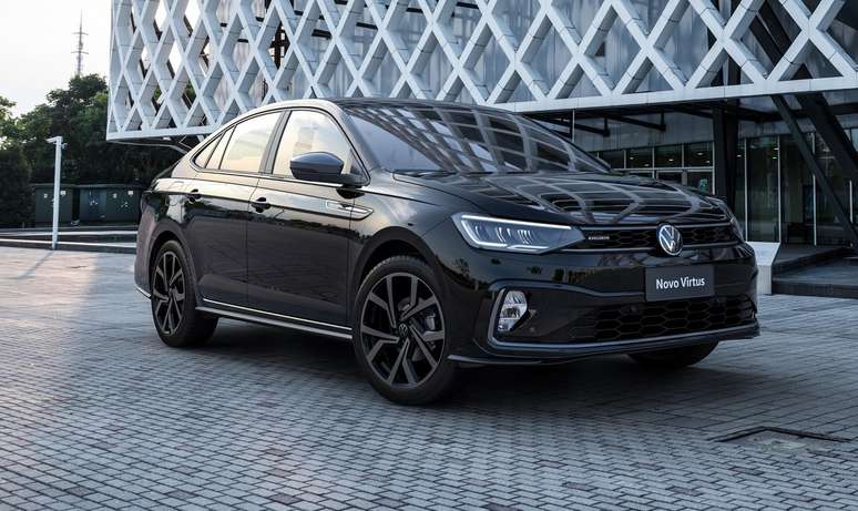 A black Volkswagen Novo Virtus sedan parked on a modern architectural backdrop, showcasing its sleek design and stylish alloy wheels.