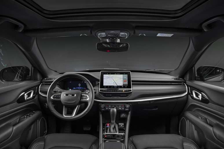 Interior view of a modern vehicle showing the dashboard, steering wheel, and infotainment screen.