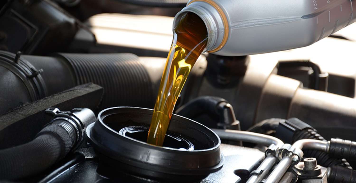 Motor oil being poured into a car engine.