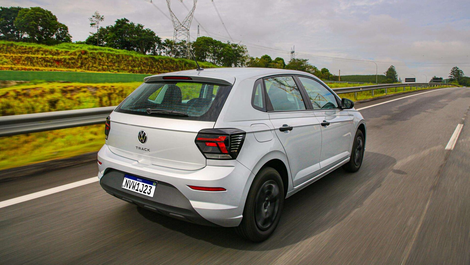 A silver Volkswagen Track car driving on a highway with green scenery on the side.