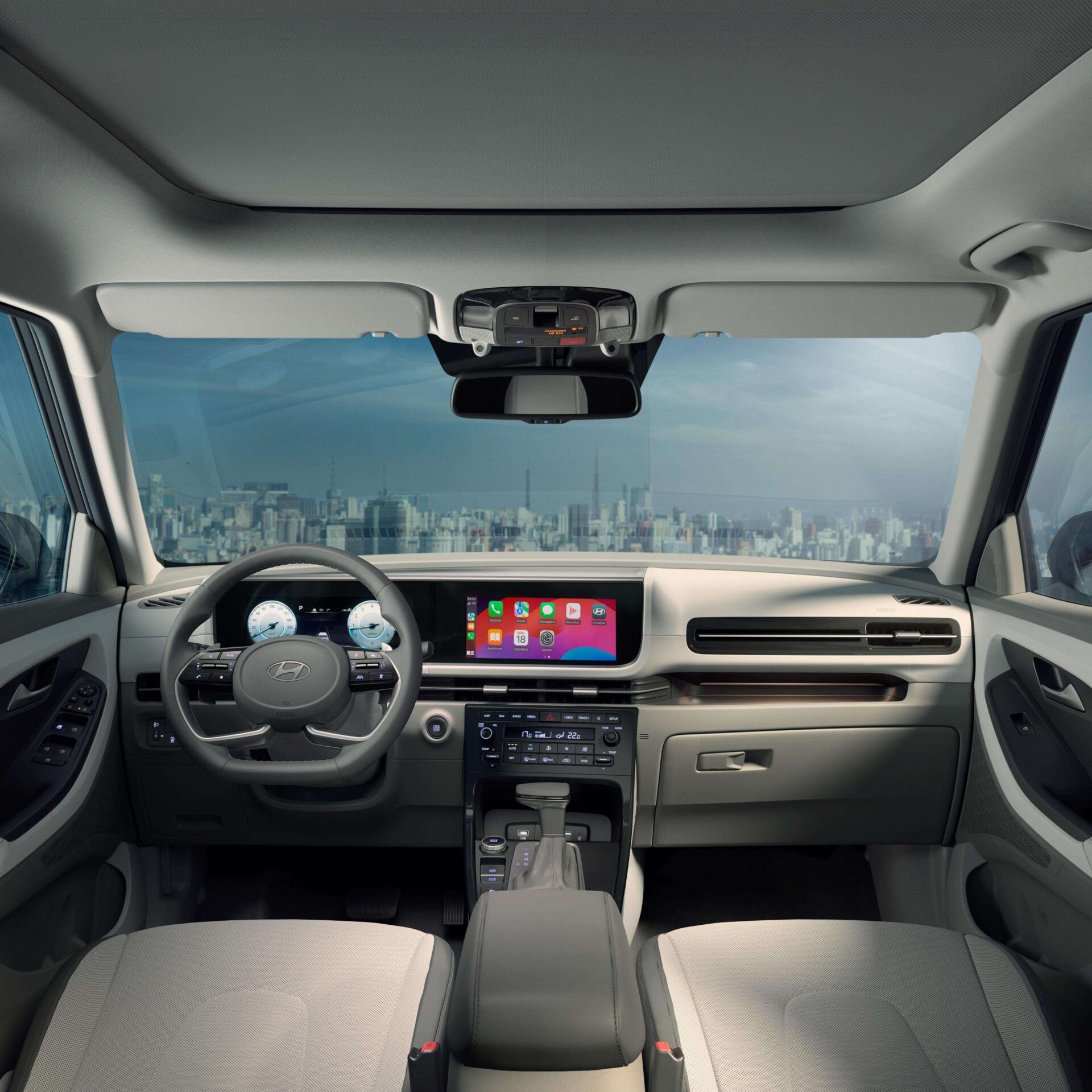 Interior view of a modern car dashboard featuring a digital display, steering wheel, and cityscape visible through the windshield.