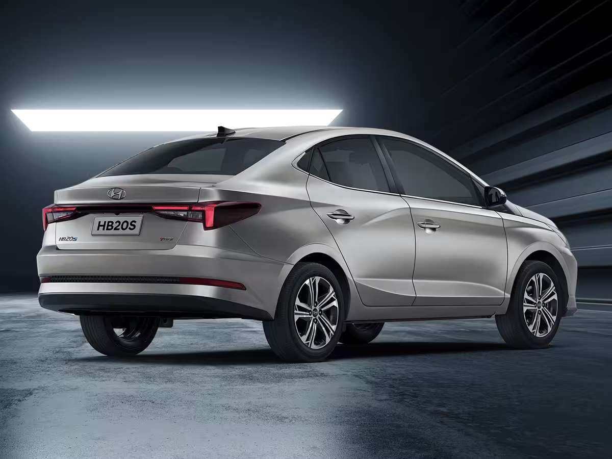 Rear view of a silver Hyundai HB20S sedan with modern design, showcased in a dark, stylish environment.