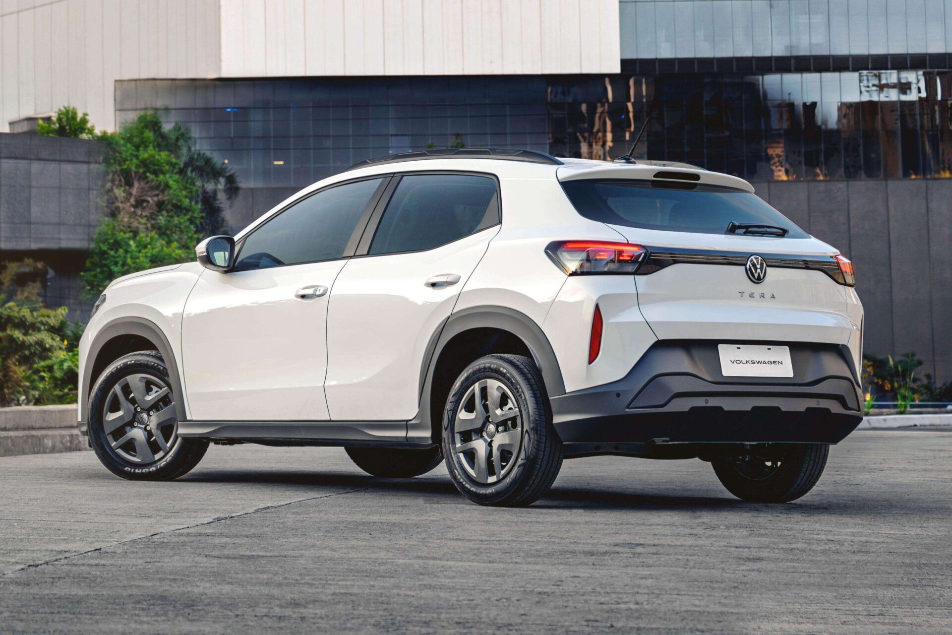 A white Volkswagen Tera SUV parked outdoors, showcasing its rear and side profile against a modern building backdrop.
