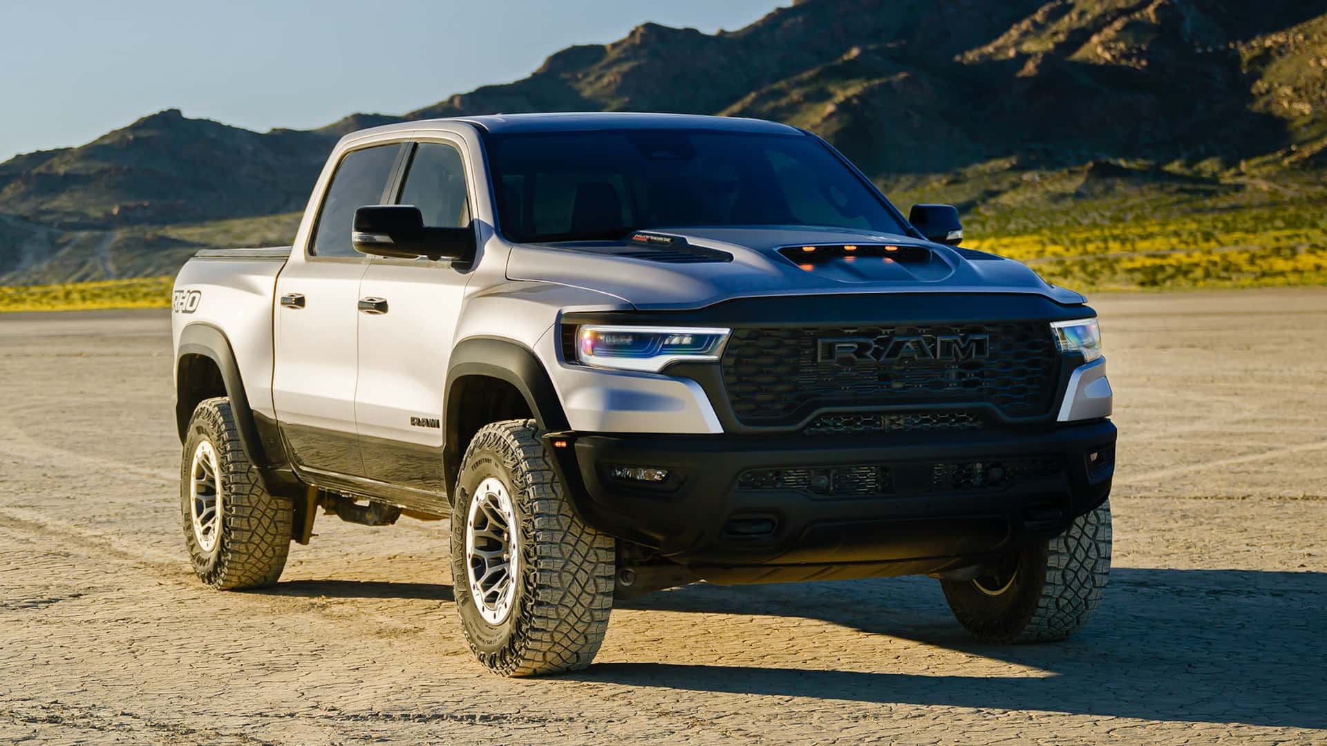 Uma caminhonete RAM 1500 TRX em uma paisagem desértica, destacando seu design robusto e pneus off-road.