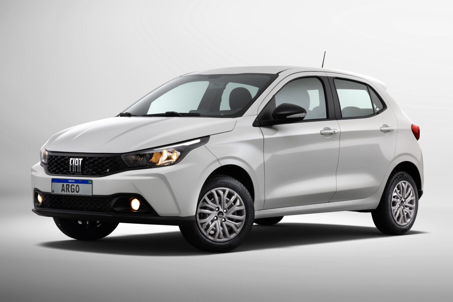 A white Fiat Argo hatchback parked against a light gray background, showcasing its modern design and features.