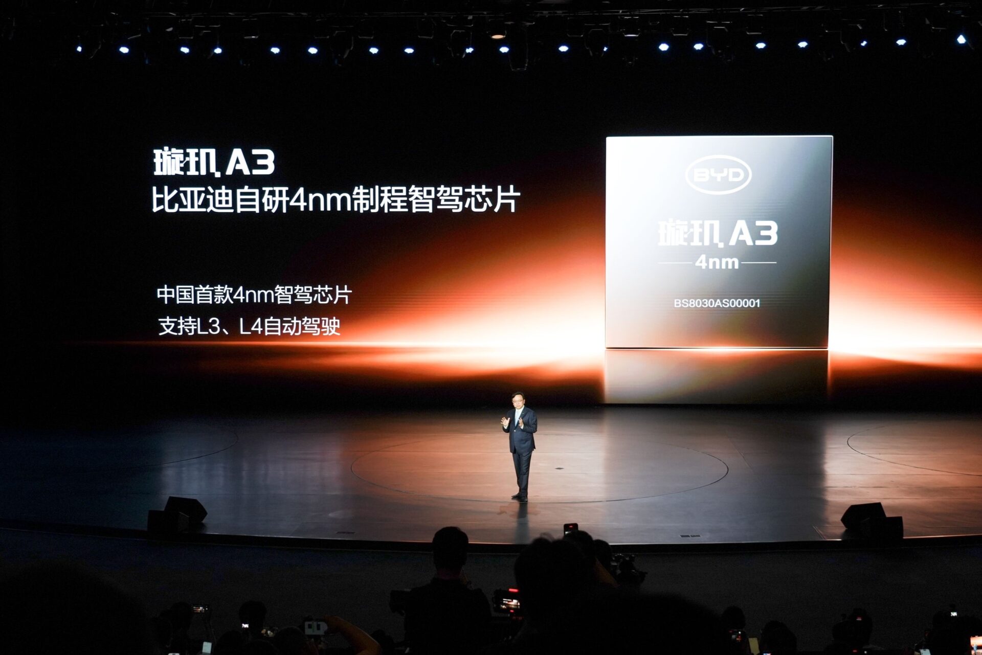Evento de lançamento do chip BYD A3 de 4nm, com apresentador no palco e backdrop informativo.