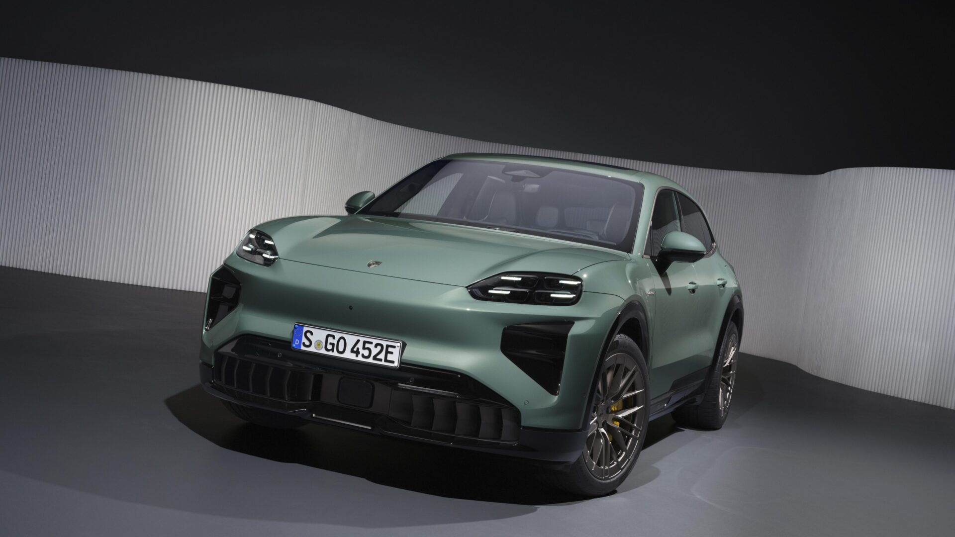 A sleek, modern SUV in a matte green finish, featuring distinctive LED headlights and a sporty design, showcased against a minimalist background.