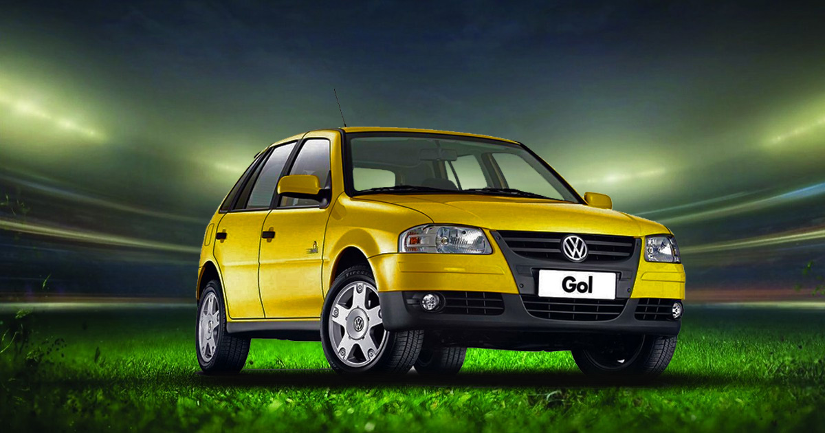 A yellow Volkswagen Gol car positioned in front of a blurred stadium background, suggesting an athletic event.