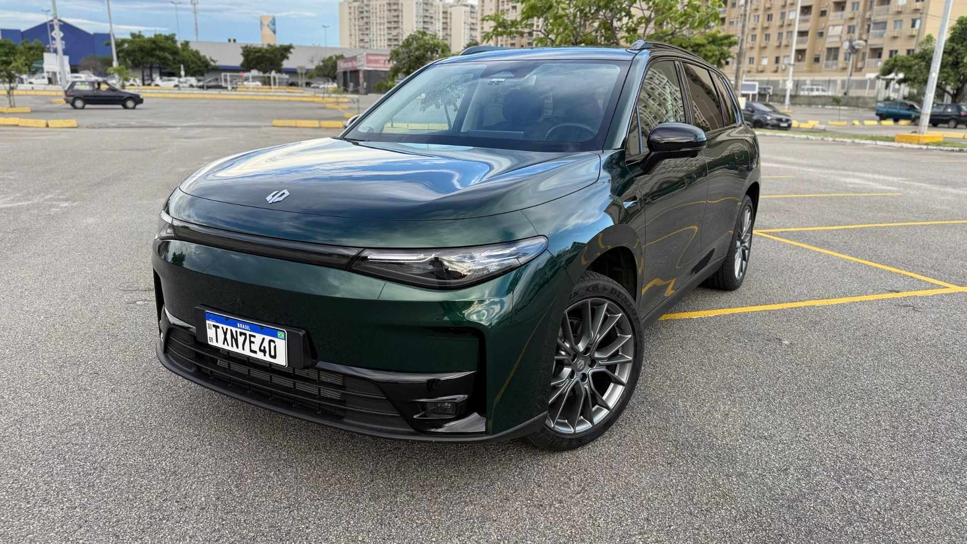 A green SUV parked in an outdoor lot, showcasing its sleek design and alloy wheels.