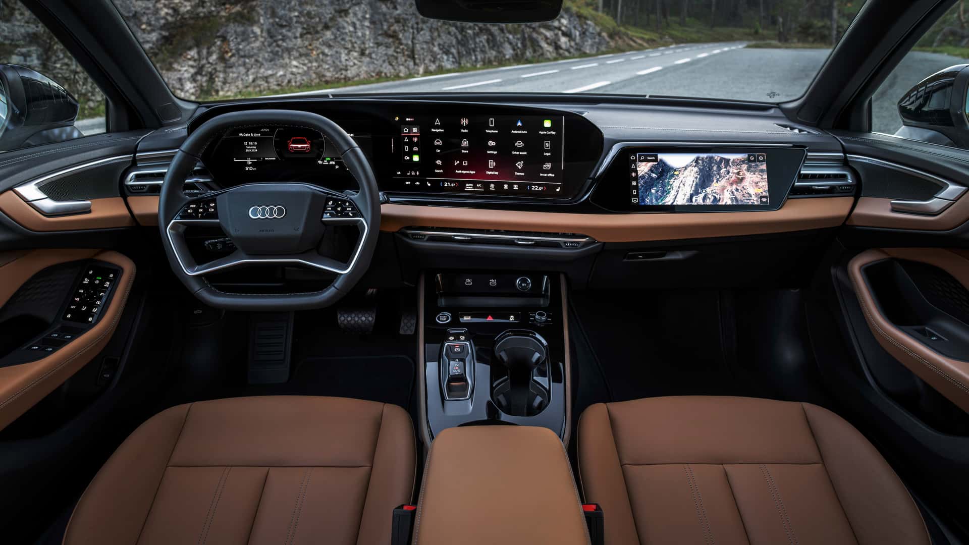 Interior view of a modern Audi car featuring a large touchscreen dashboard, a digital instrument cluster, and leather seats.
