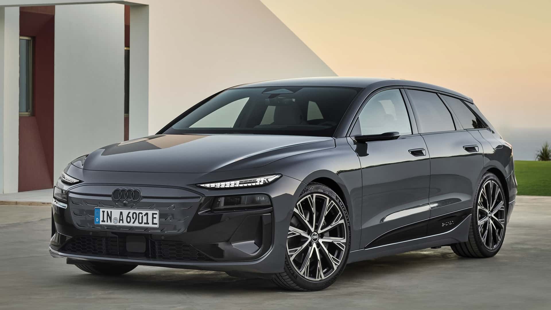 A sleek, modern Audi electric vehicle parked in front of a minimalist architectural background, showcasing its elegant design and alloy wheels.
