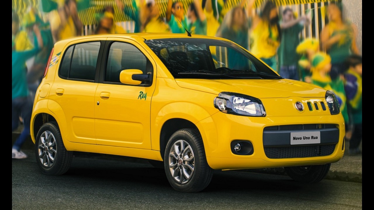 A bright yellow Fiat car parked in front of a blurred background featuring people celebrating with green and yellow colors.