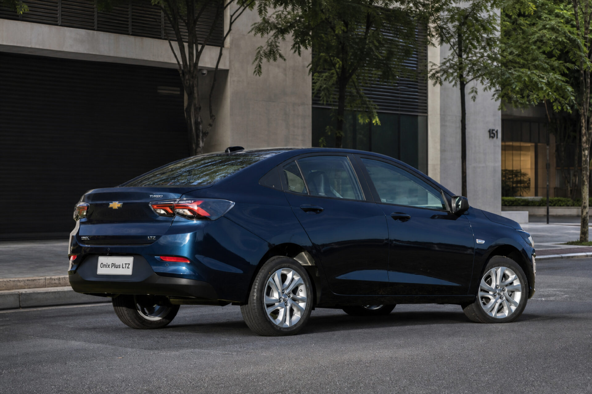 A blue Chevrolet Onix Plus LTZ parked on a city street, showcasing its sleek design and modern features.