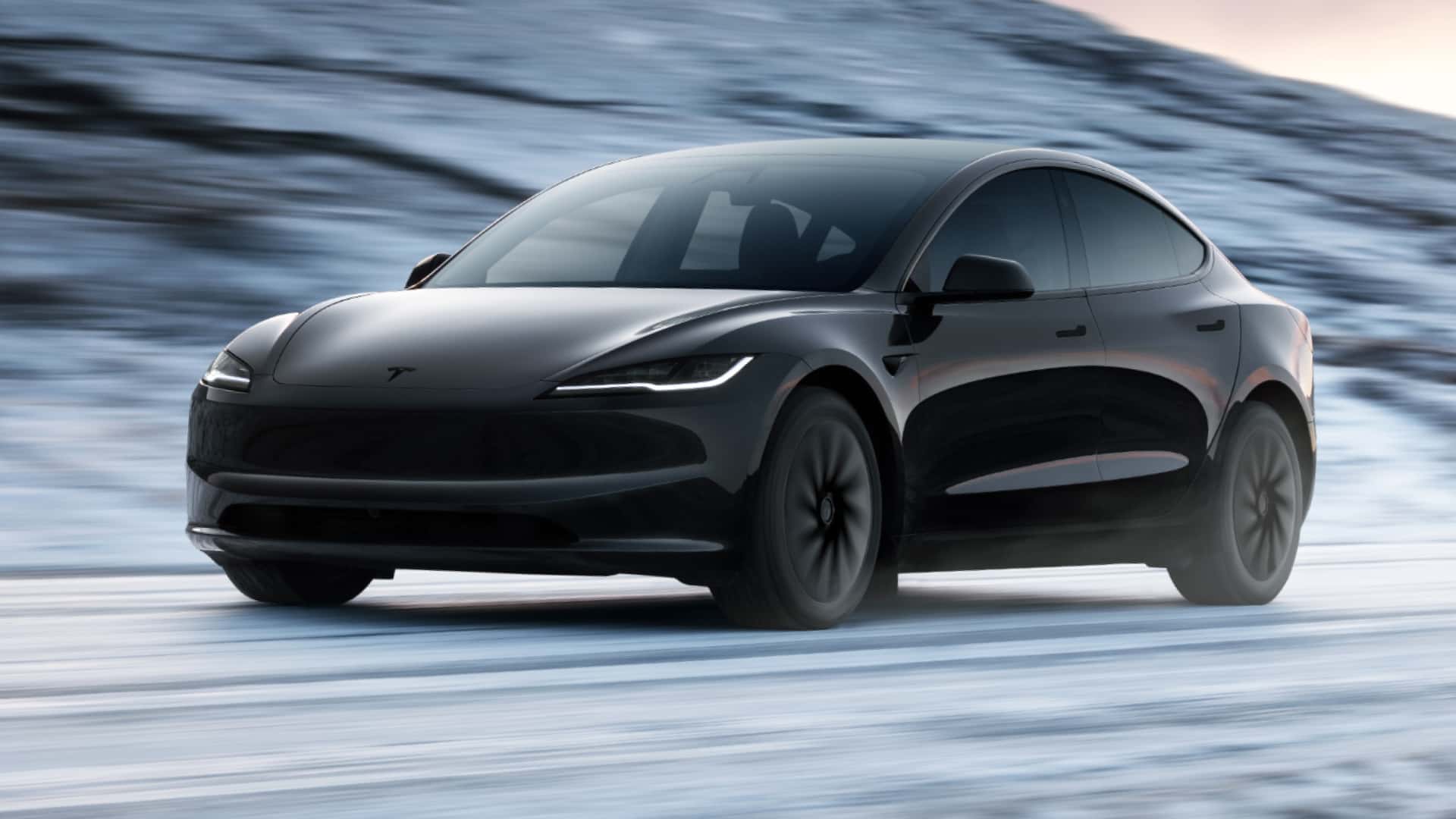 A black Tesla car driving on a snowy surface, showcasing a sleek and modern design.