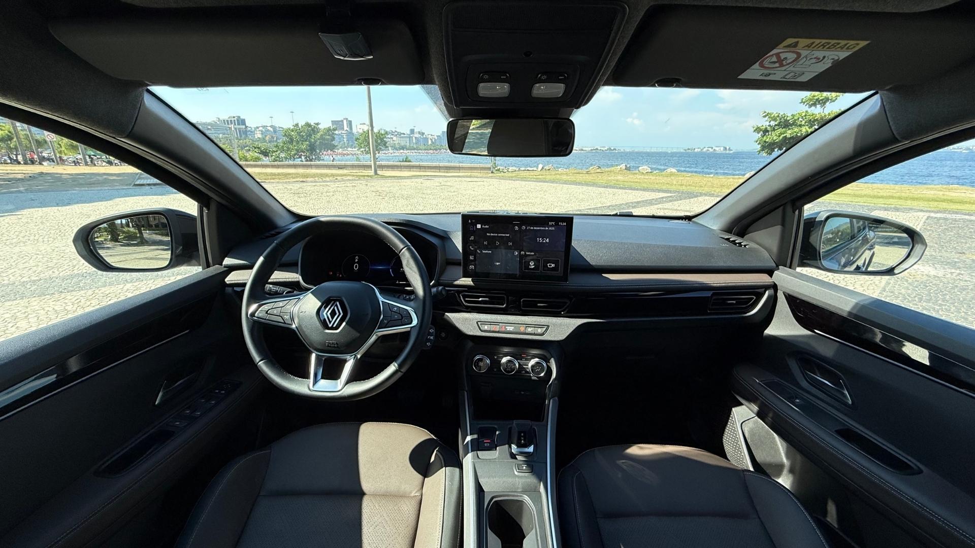 Interior view of a Renault car showcasing the steering wheel, dashboard with touchscreen display, and front seats, with a scenic background of a waterfront.