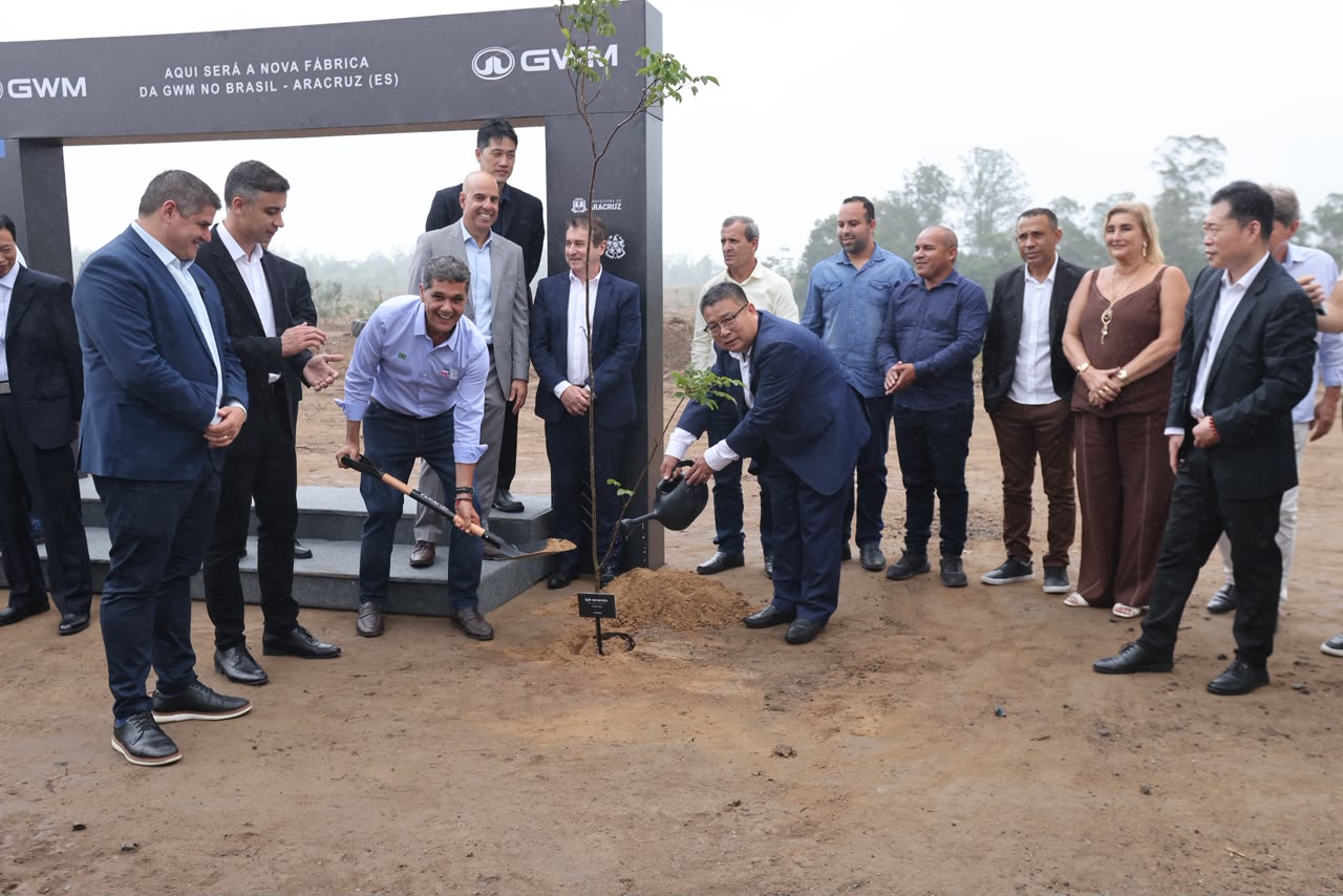 Group of people attending a tree planting ceremony for the new GWM factory in Aracruz, Brazil, with some individuals holding shovels and watering cans.