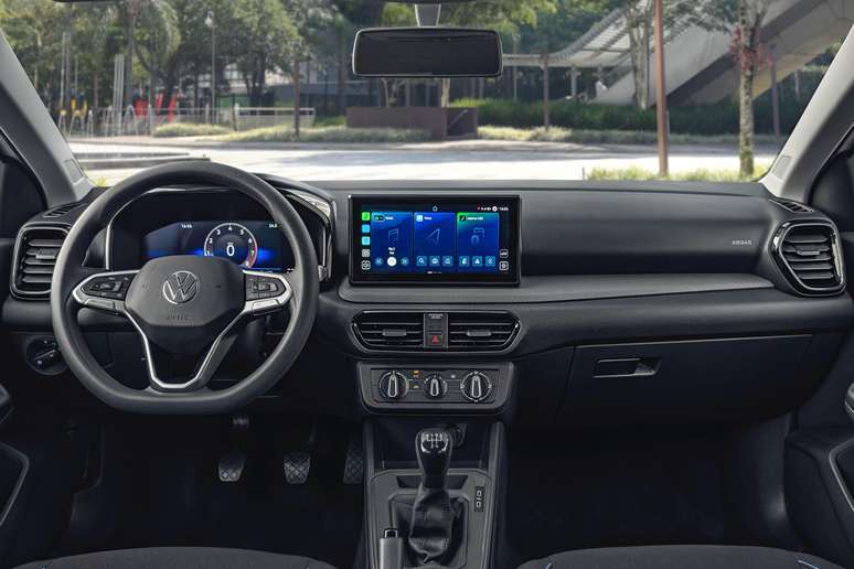 Painel de controle interior de um carro Volkswagen, mostrando o volante, painel digital, e sistema de áudio com tela touchscreen.