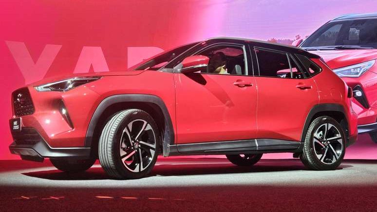 SUV vermelho em apresentação com fundo iluminado em tom rosa.