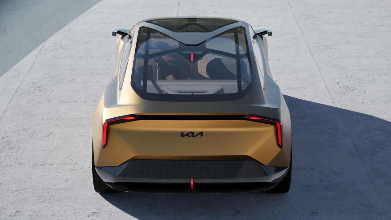 Vista traseira de um carro conceito da Kia, com design futurista e teto de vidro. O veículo está posicionado em uma superfície clara.