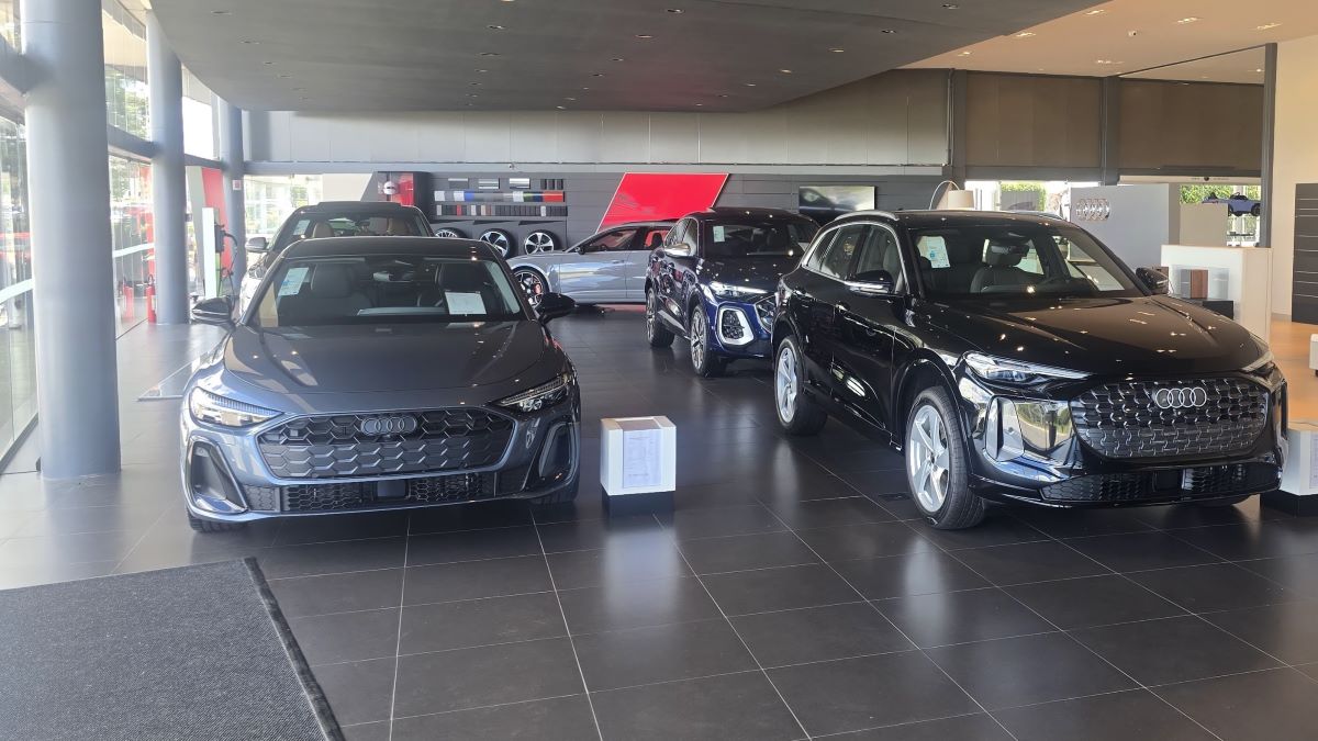 Mostra de veículos Audi em uma concessionária com carros em exibição em um ambiente moderno.