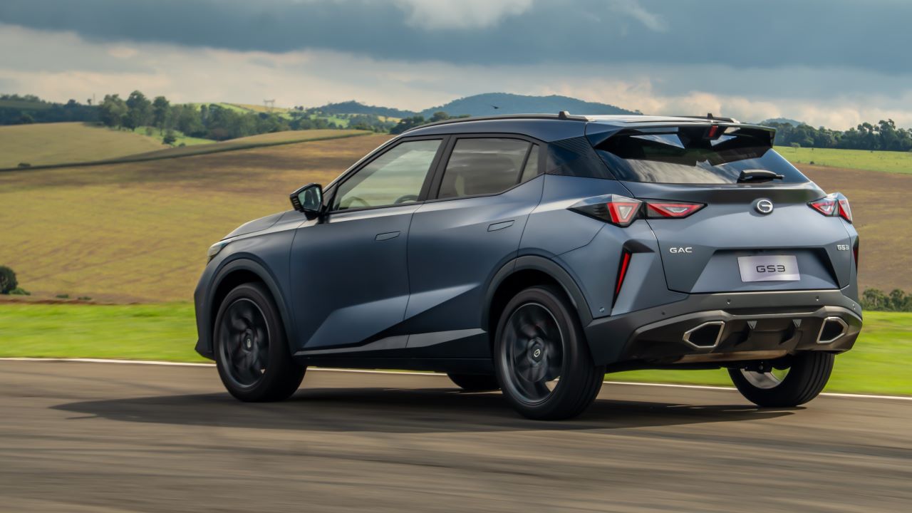 SUV GAC GS3 em movimento em um circuito, com uma paisagem montanhosa ao fundo.