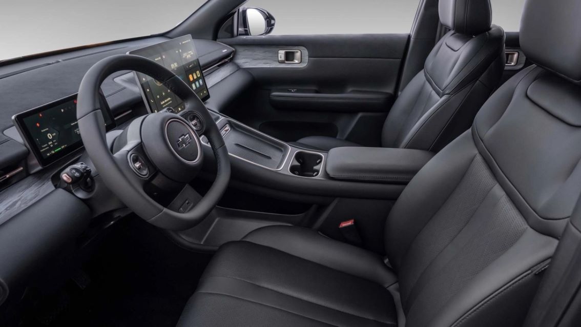 Interior moderno de um carro com volante, console central e telas digitais.