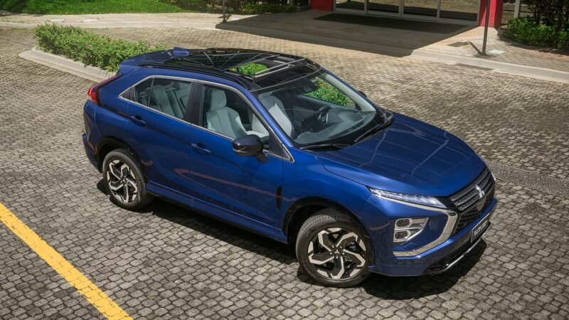 Um carro SUV azul estacionado em um calçamento de pedras, com um teto solar e interior claro visível.