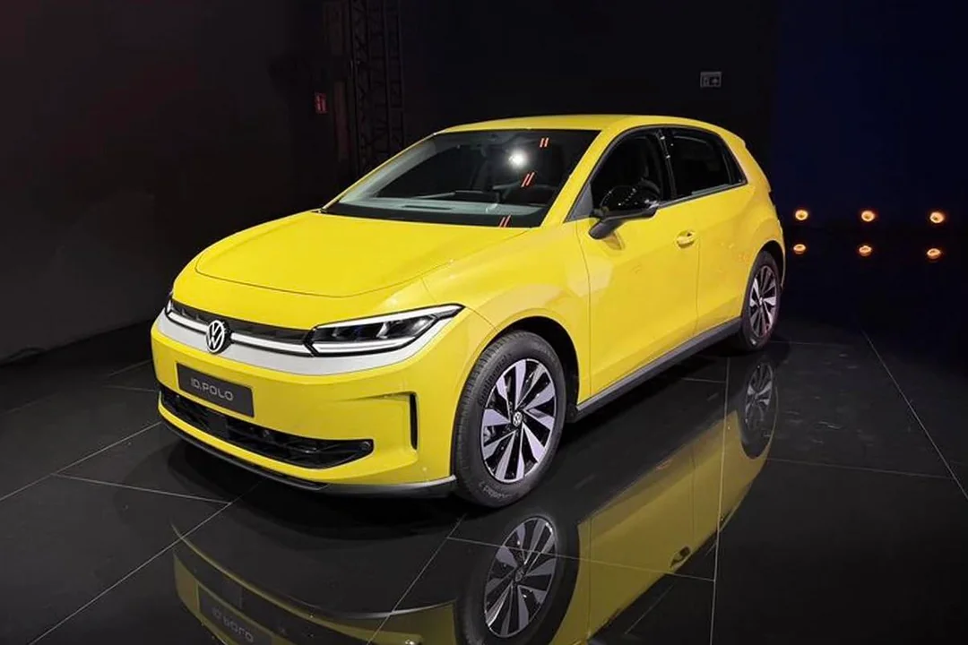Carro elétrico Volkswagen ID. Polo na cor amarela, com design moderno e elegante, exposto em um ambiente escuro com luzes destacando o veículo.