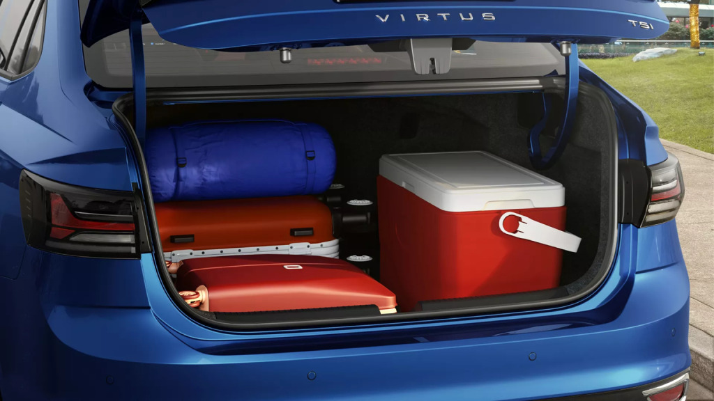 Malas e um cooler vermelho organizados no porta-malas de um carro azul.