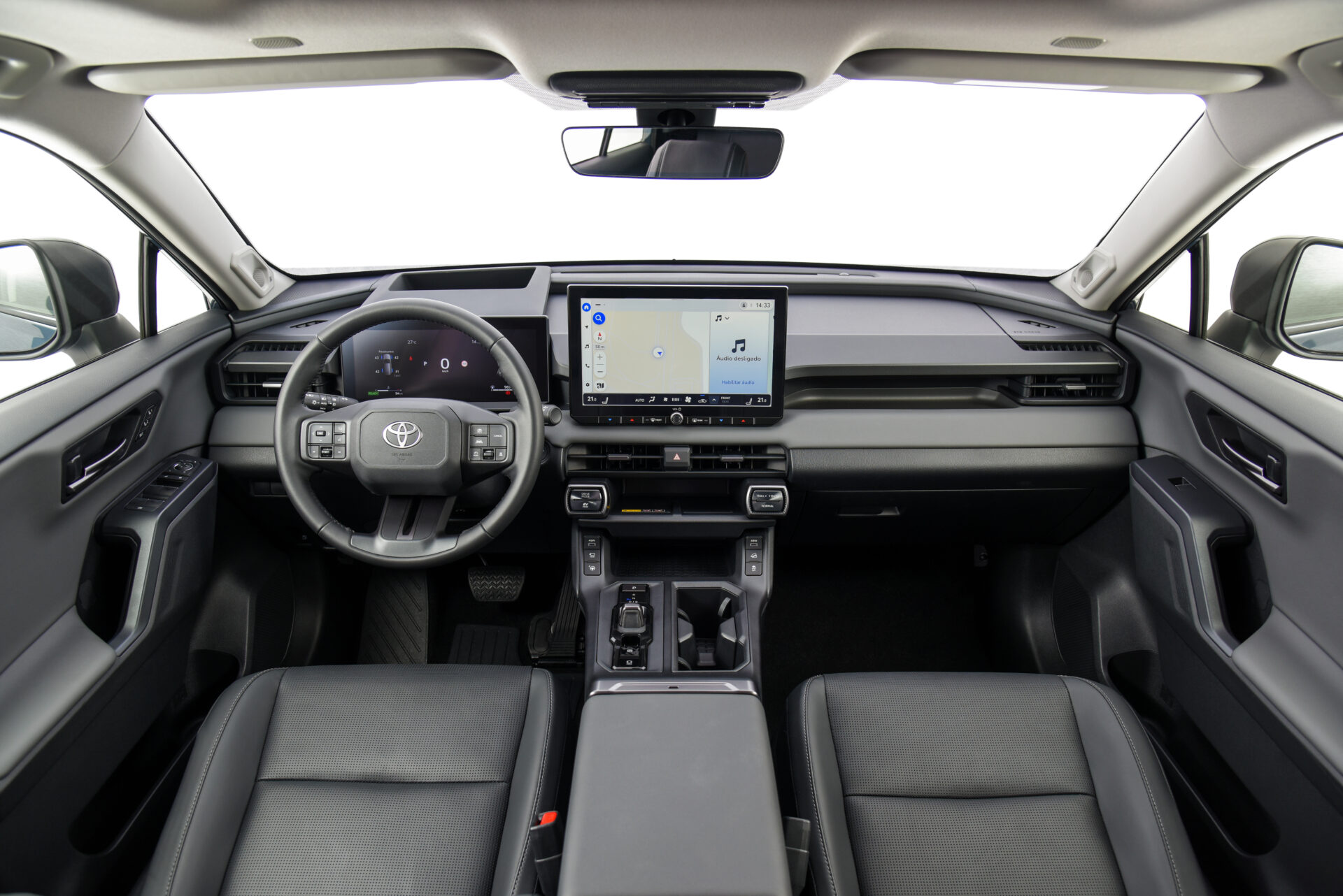 Interior de carro com volante, painel digital e uma tela de navegação ao centro.
