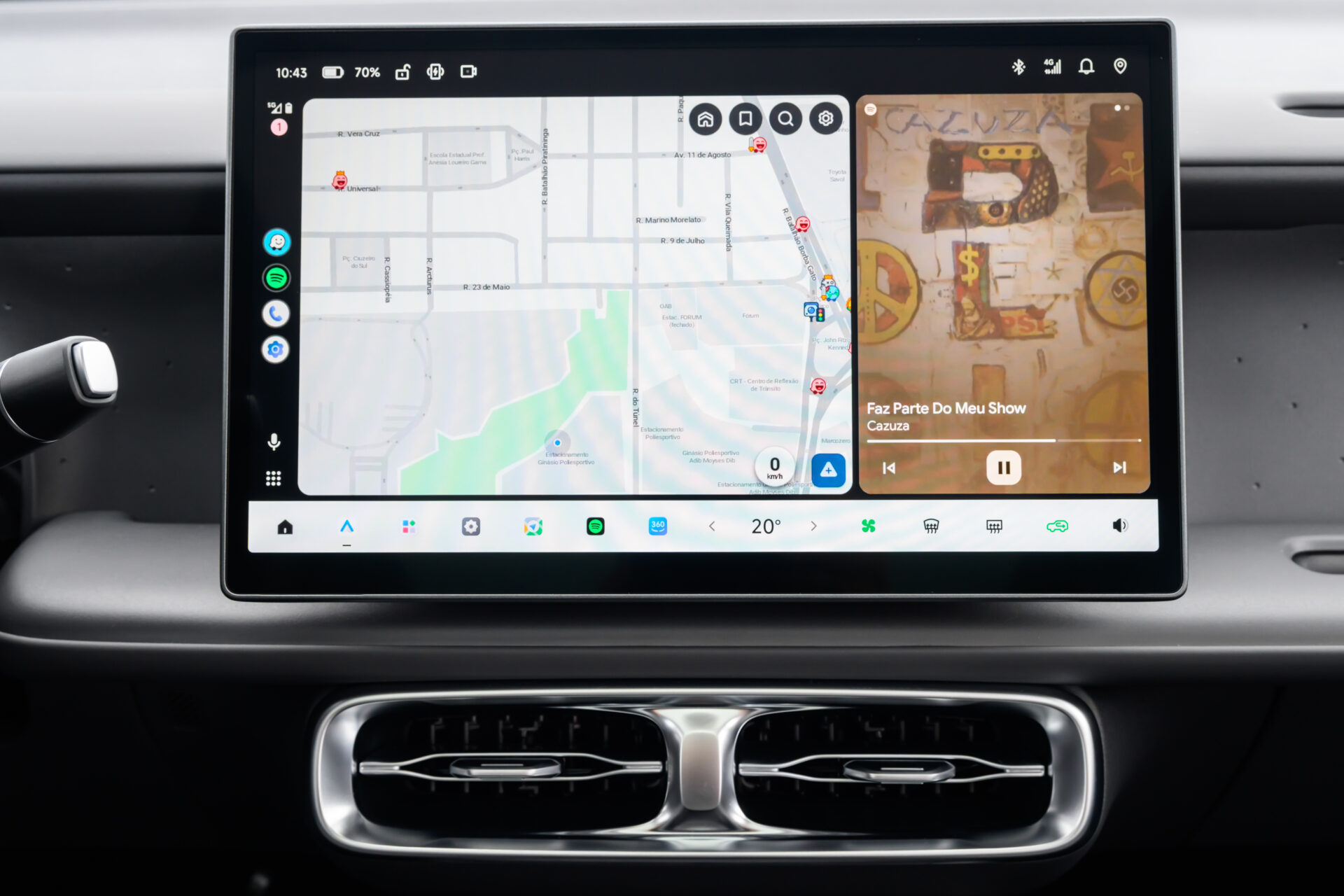 Tela de infotainment de um carro mostrando um mapa e informações de música.