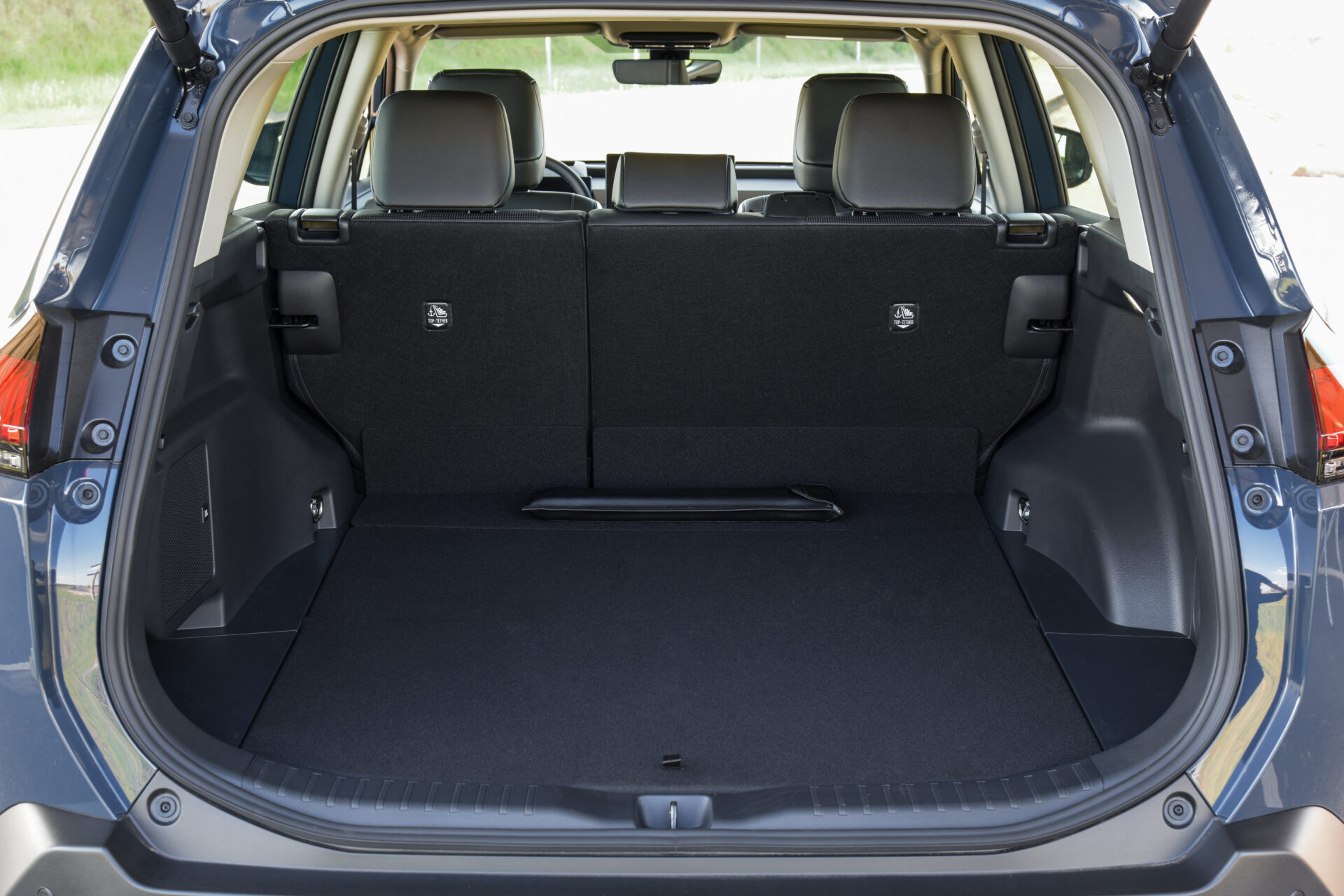 Interior de um porta-malas de SUV com os bancos traseiros rebatidos, mostrando um espaço amplo e plano.