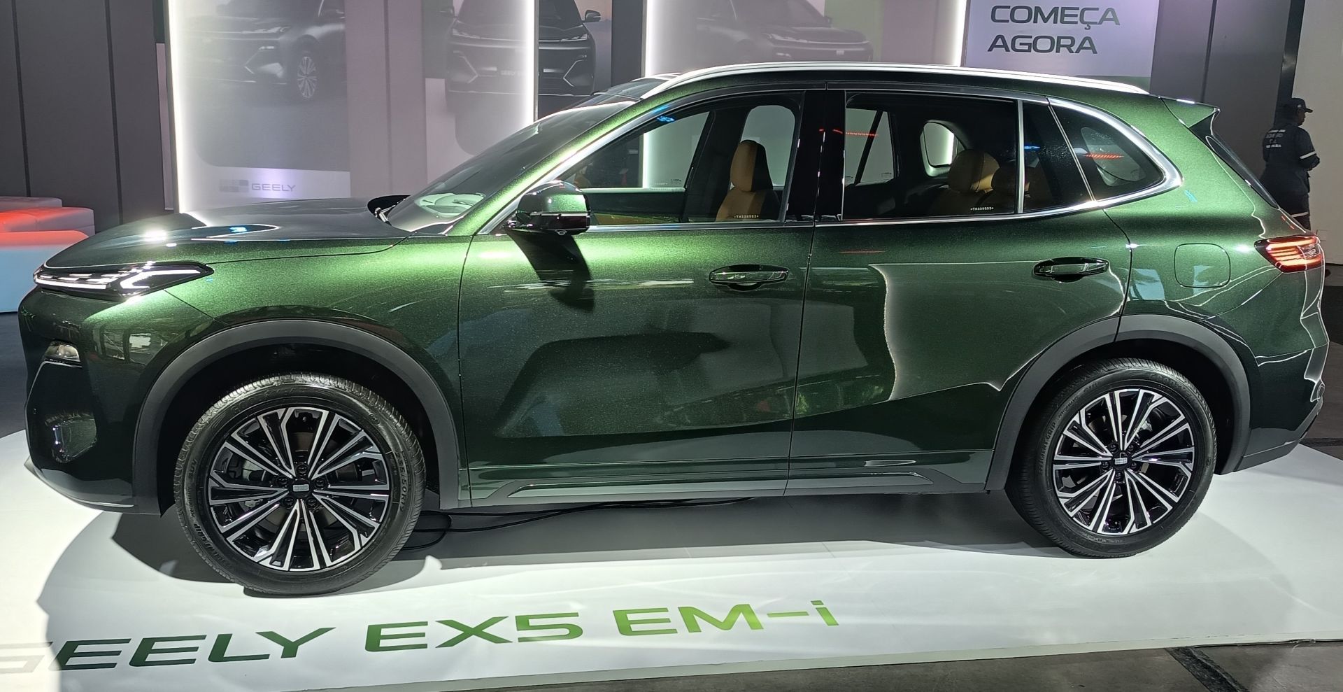 SUV Geely EX5 EM-i na cor verde metálico, exibido em um evento automobilístico.