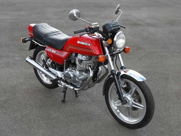 Moto Honda CG 125 vermelha, vista lateral, com design clássico e banco de couro preto.