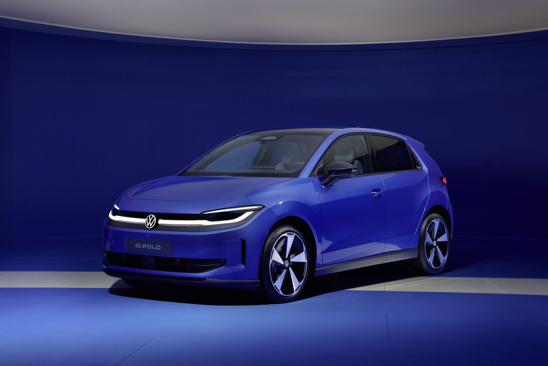 Carro modelo ID. Polo da Volkswagen em um fundo azul, destacando seu design moderno e estiloso.