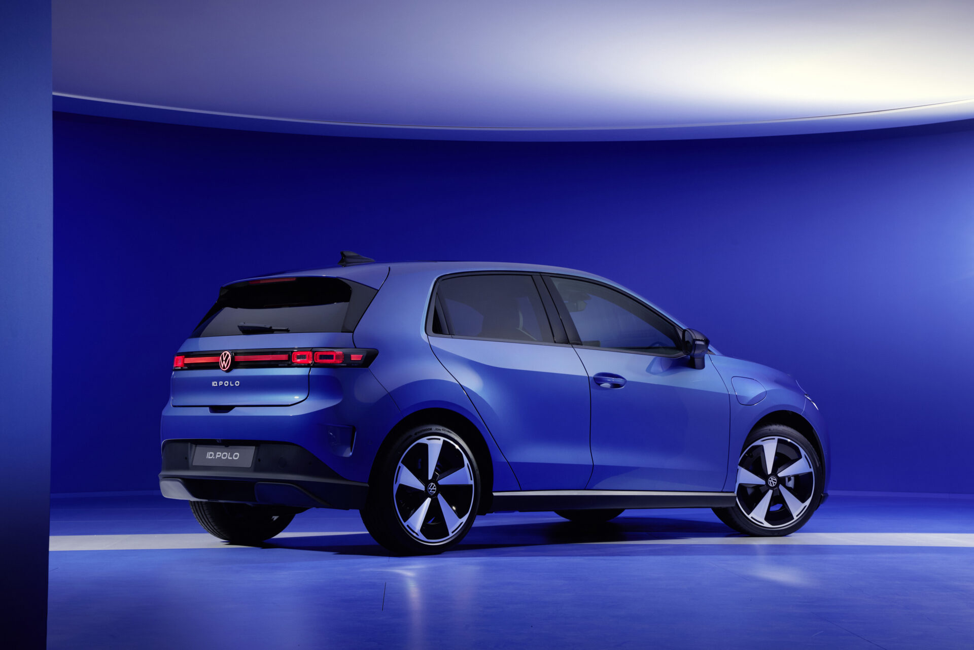 Imagem do Volkswagen ID. Polo em um fundo azul, mostrando a parte traseira e lateral do carro.