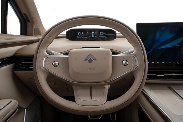 Interior de carro com volante moderno e painel digital visível ao fundo.