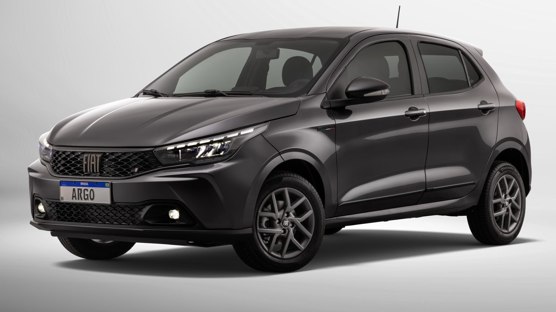 Carro vermelho modelo Fiat Argo em um fundo neutro.