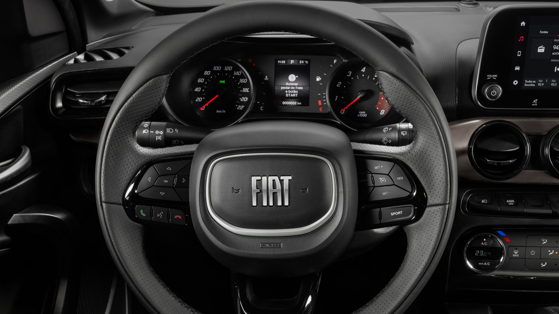 Volante de carro da Fiat com painel de instrumentos e controles integrados visíveis.
