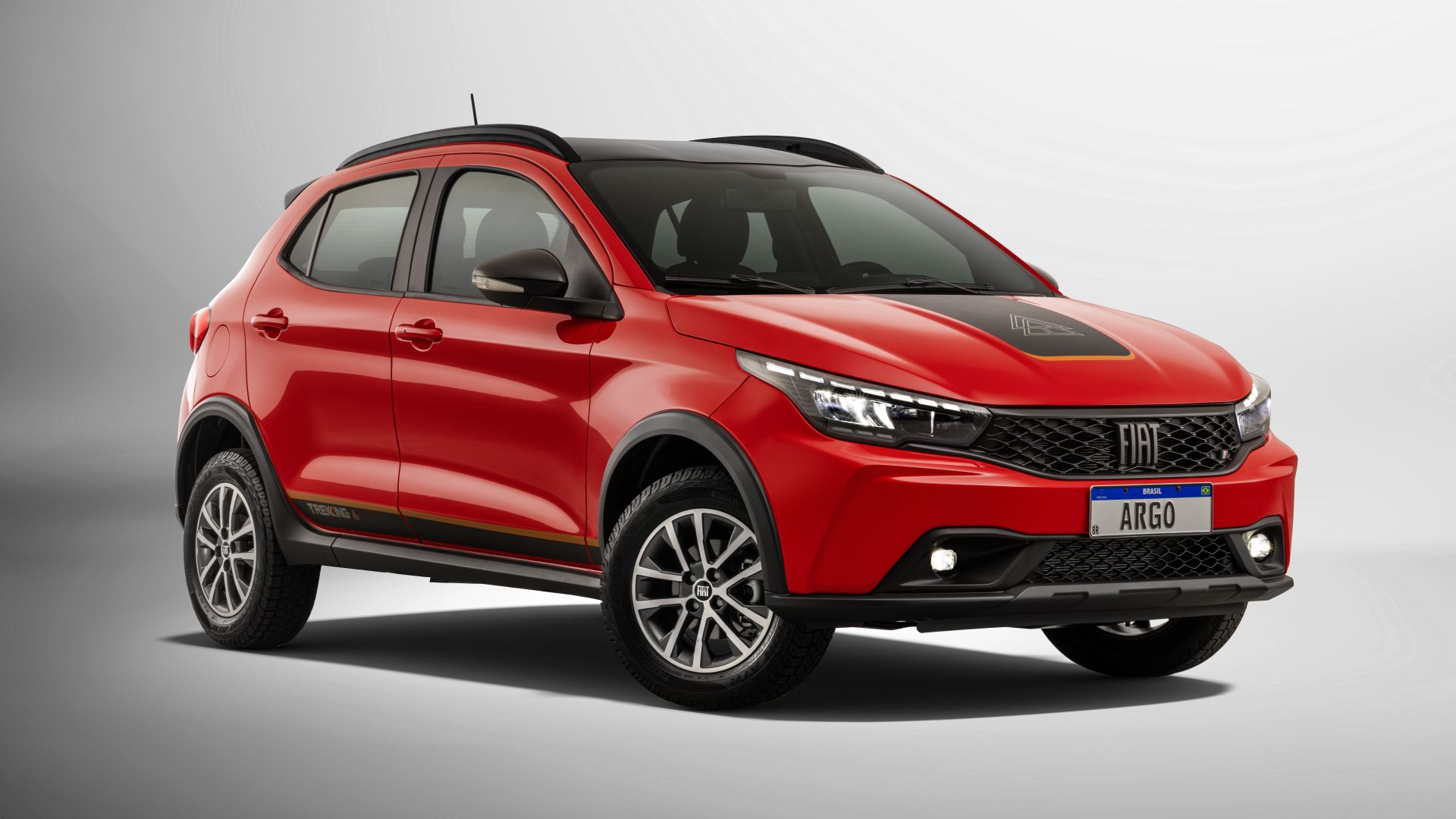 Carro esporte utilitário vermelho da marca Fiat, modelo Argo, exibido em fundo claro com detalhes em preto.
