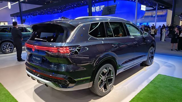 SUV moderno na exposição, visto de trás, com design elegante e cores escuras.