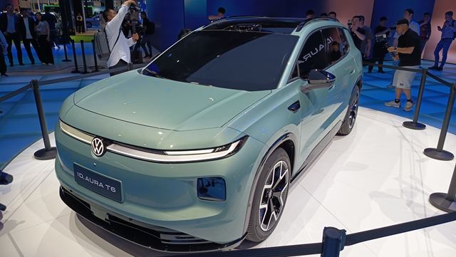 Carro elétrico Volkswagen ID. Aura T6 exibido em um evento, com design moderno e elegante, na cor verde menta.