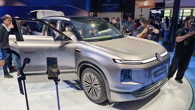 SUV da Volkswagen em exposição, com porta aberta, rodeado por espectadores tirando fotos.