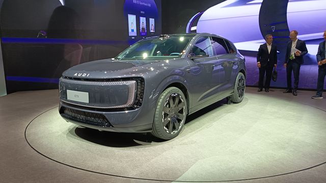 Um SUV elétrico Audi exibido em um evento, com um design moderno e sofisticado, em destaque no centro da imagem.