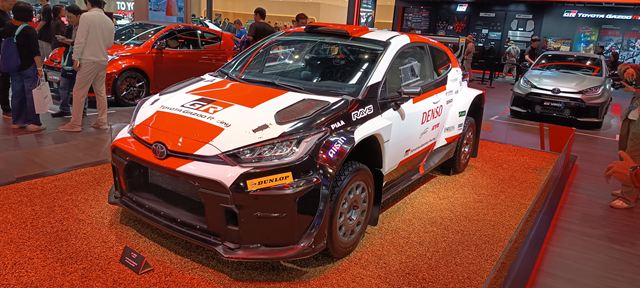 Carro esportivo Toyota com pintura branca e laranja em exibição em evento automotivo, destacando-se na exposição.