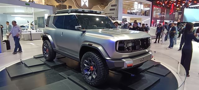 Veículo conceito em exibição em uma feira de automóveis, com design robusto e rodas grandes.