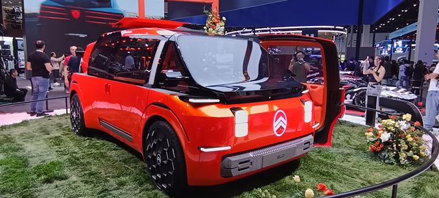 Veículo conceito da Citroën, modelo futurista e colorido, estacionado em uma área verde com flores, em um evento automotivo.