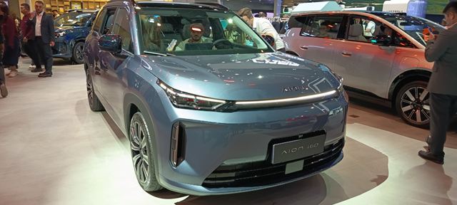 SUV elétrico Aion 10 em exposição, destacando sua cor azul e design moderno.