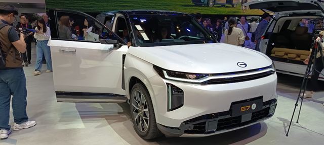 Veículo SUV branco com porta dianteira aberta em uma feira, exibindo seu design moderno e atraente.